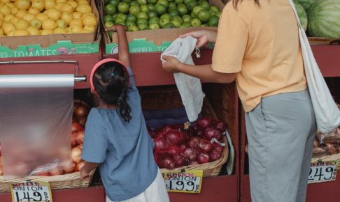 ethnic woman with daughter picking limes in market